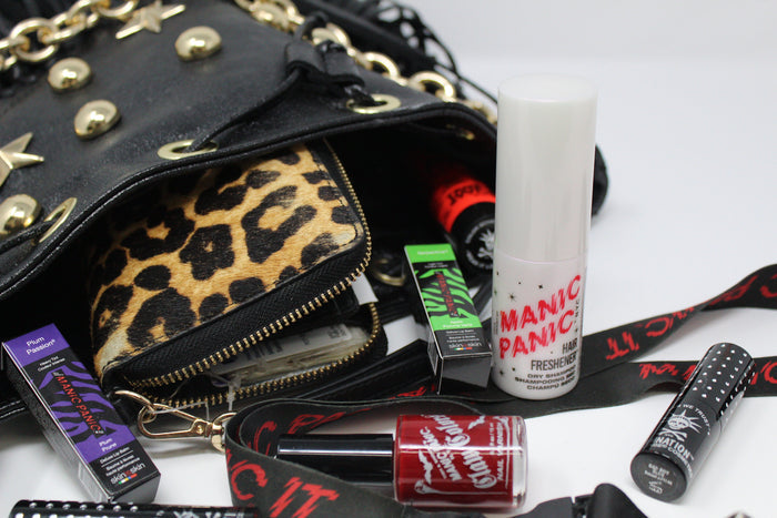Purse with Manic Panic item spilling of focused on the  Aerosol-free pump bottle of Manic Panic Hair Freshener