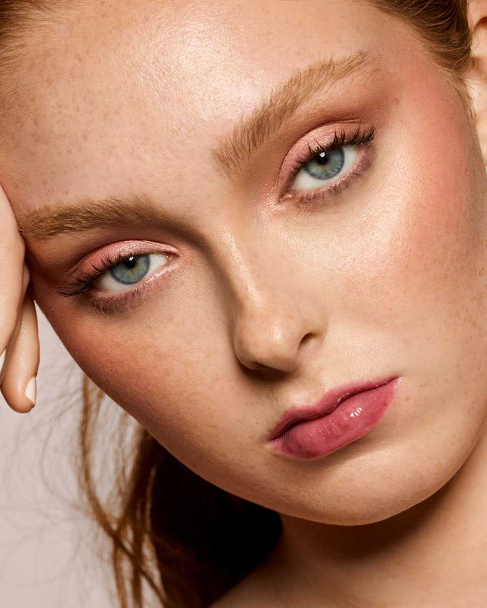 light skin toned model wearing gloss bomb universal lip luminizer in shade RiRi