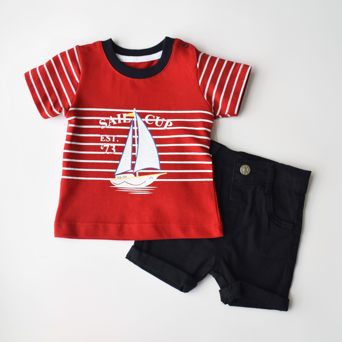 Baby boy’s nautical-themed summer outfit featuring a red striped T-shirt with a sailboat print and “Sail Cup” text, paired with black cotton shorts.